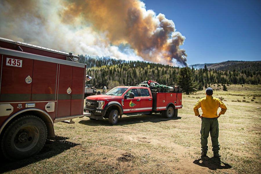 Firefighter Ryan Le Baron with the Elk Creek fire department out of Colorado watches the fire blaze across a ridgeline near the Taos County line as firefighters from all over the country converge on Northern New Mexico to battle the Hermit's Peak and Calf Canyon fire on May 13, 2022.