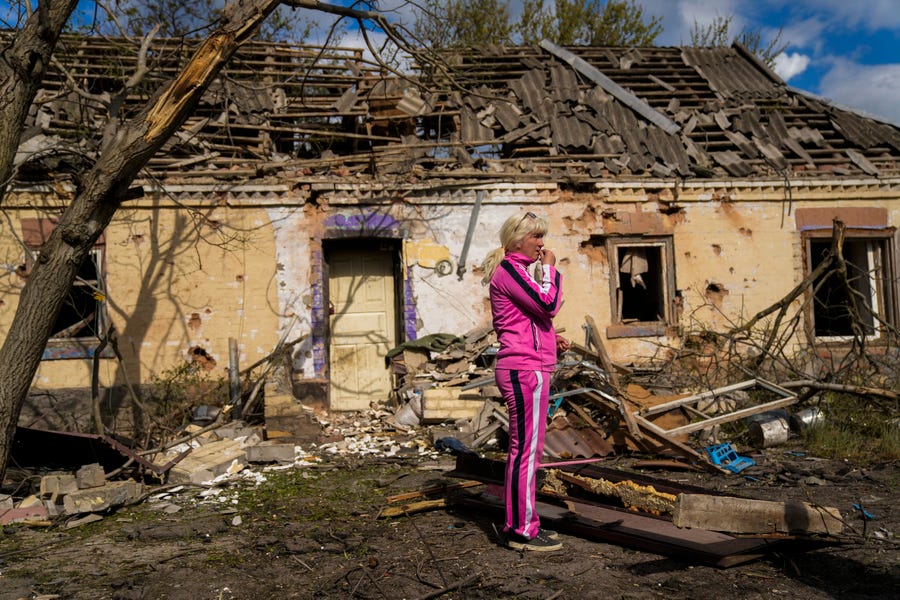 Iryna Martsyniuk, 50, stands next to her house, heavily damaged after a Russian bombing in Velyka Kostromka village, Ukraine, Thursday, May 19, 2022. Martsyniuk and her three young children were at home when the attack occurred in the village, a few kilometers from the front lines, but they all survived unharmed. 