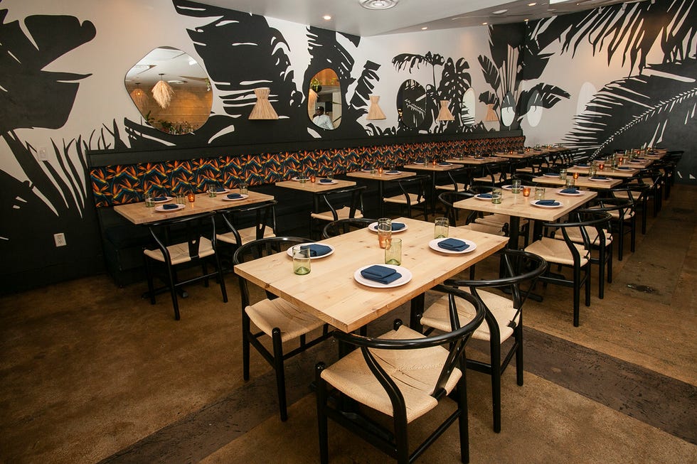 The dining room at Canje is painted with palm fronds and banana leaves.