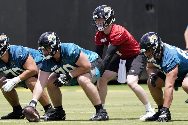 Jacksonville Jaguars center Luke Fortner front left, snaps the ball to quarterback E.J. Perry during NFL football rookie minicamp, Friday, May 13, 2022, in Jacksonville, Fla. (AP Photo/John Raoux)