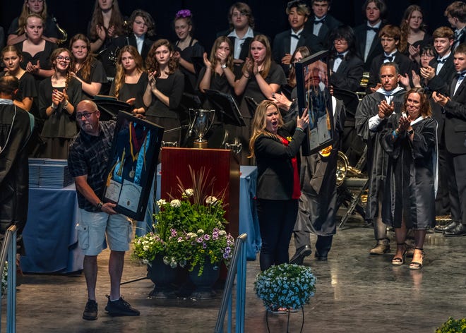 Jill Soave and Craig Shilling hold displays Thursday including a diploma for for their son, Oxford High School senior Justin Shilling, who was one of four students killed during a mass shooting Nov. 30 at the school. The parents attended the graduation ceremony for Oxford High School class of 2022 at Pine Knob Music Theater in Clarkston.