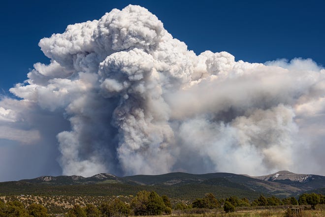 A tower of smoke from the Calf Canyon / Hermits Peak fire rises northeast of Jicarita Peak on May 15, 2022.