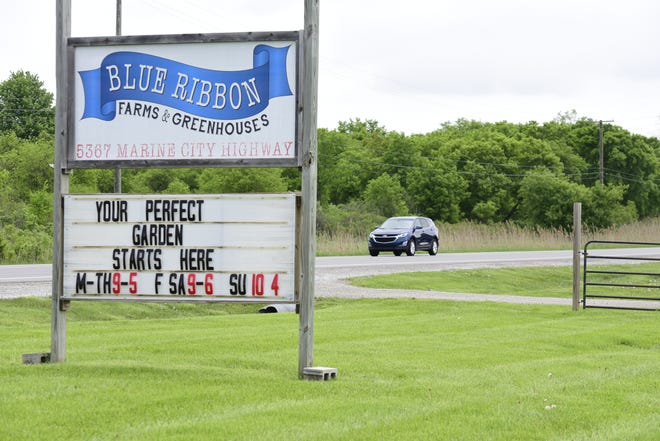 A car passes by the Blue Ribbon Farms and Greenhouse on Marine City Highway on Friday, May 20, 2022. St. Clair County officials are weighing the feasibility of using American Rescue Plan funds to help build infrastructure, like new water and sewer access, on an 11-mile stretch of the roadway to accommodate future growth.