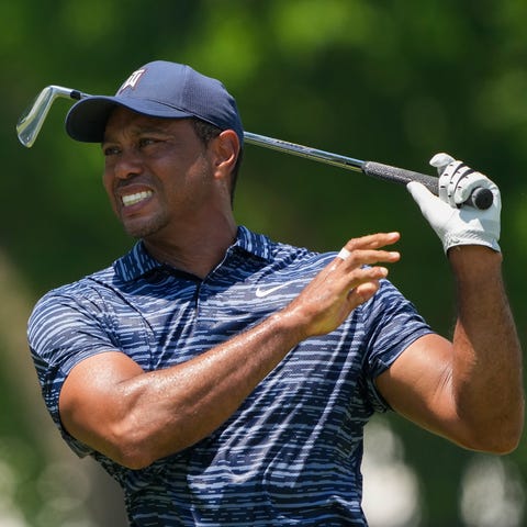 Tiger Woods grimaces as he plays a shot on the nin