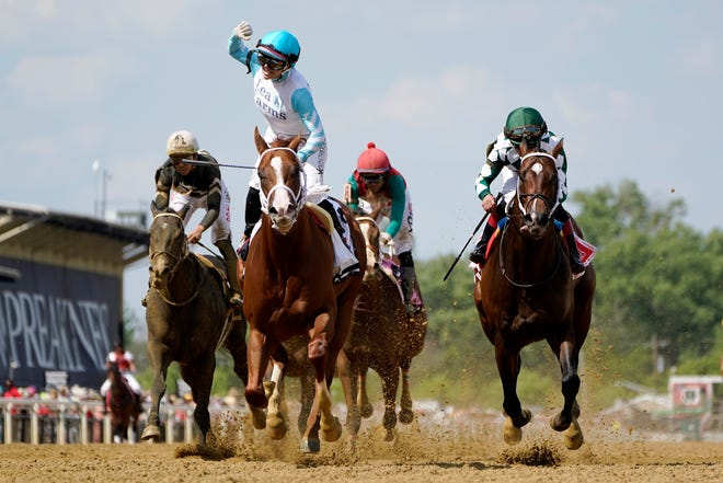 Chantal Sutherland, second from left, atop Lightening Larry, edges out Joe Rosario, right, atop Cogburn, to win the Chick Lang Stakes undercard race prior to the 147th running of the Preakness Stakes horse race at Pimlico Race Course, Saturday, May 21, 2022, in Baltimore.