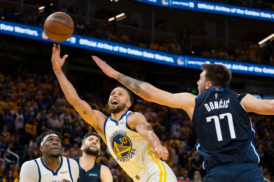 West finals: Warriors guard Stephen Curry (30) drives and shoots over Mavericks defender Luka Doncic (77) during the second half of Game 2.