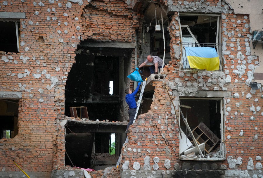 Residents remove their belongings May 21 after their house was ruined by Russian shelling in Irpin, close to Kyiv, Ukraine.