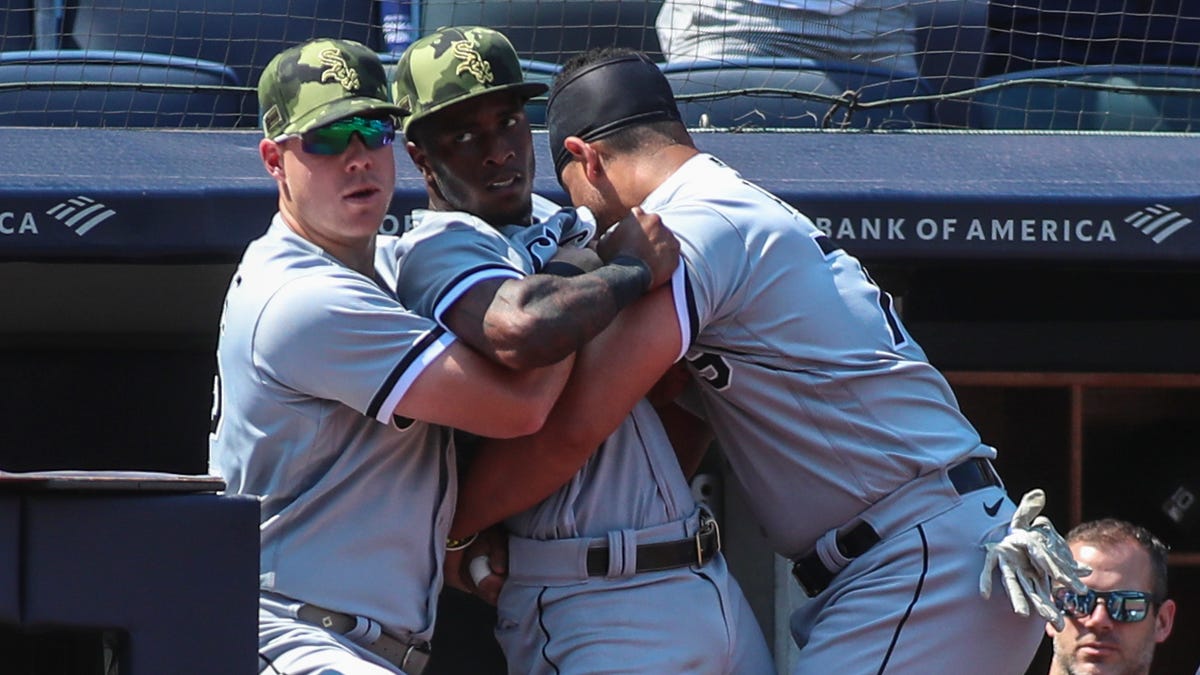 Teammates restrain Tim Anderson after the dugouts emptied in the fifth inning.