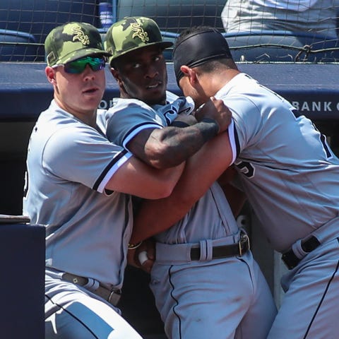 Teammates restrain Tim Anderson after the dugouts 