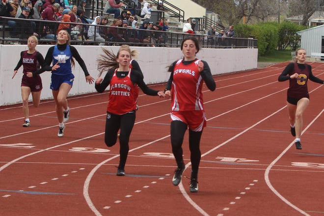 Conrad's Taylor Evans (center right) crosses the finish line 22/100 of a second ahead of Blaire Westby of the Glasgow Scotties to win the girls' 200 meters Saturday at the Northern B Divisional Meet at Memorial Stadium.
