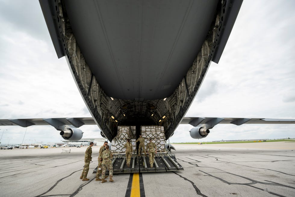 Crew members of an Air Force C-17 prepare to unload baby formula after its arrival from Ramstein Air Base in Germany. The arrival of the first shipment of formula brought to the United States under Operation Fly Formula in response to the infant formula shortage caused by Abbott Nutrition’s voluntary recall arrived at the Indianapolis International Airport, Sunday, May 22, 2022, on a Air Force C-17.