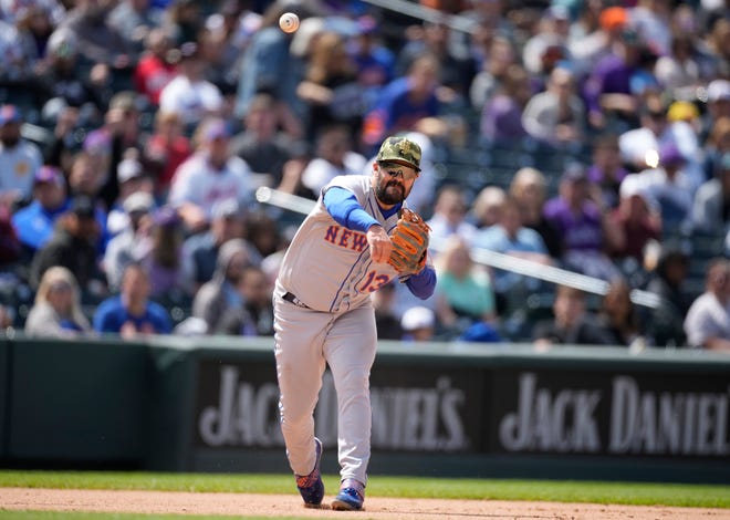 New York Mets third baseman Luis Guillorme throws to first base to put out Colorado Rockies' Brian Serven in the seventh inning of a baseball game, Sunday, May 22 2022, in Denver.