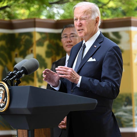 President Joe Biden speaks to the media next to Hy