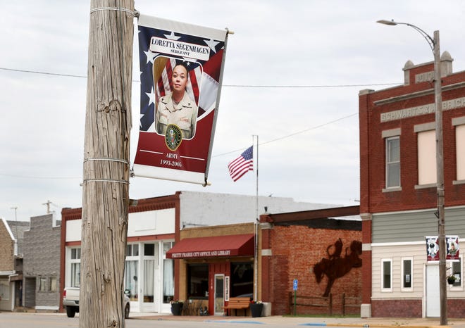 A patriotic banner with a photo of Army veteran Loretta Segenhaen is displayed on the north side of Main Street Monday, May 23, 2022, in Pretty Prairie.