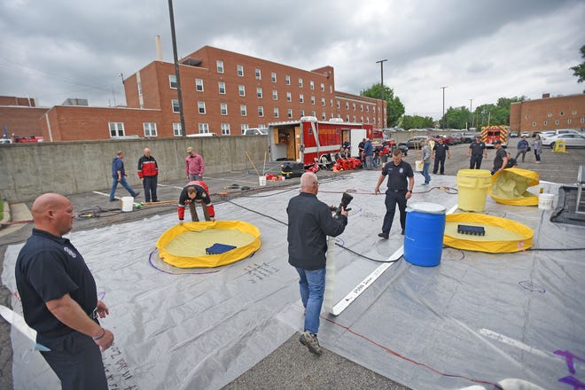 The staff of OhioHealth and the Mansfield Fire Department work together Monday afternoon in a hazmat disaster drill in the hospital parking lot.