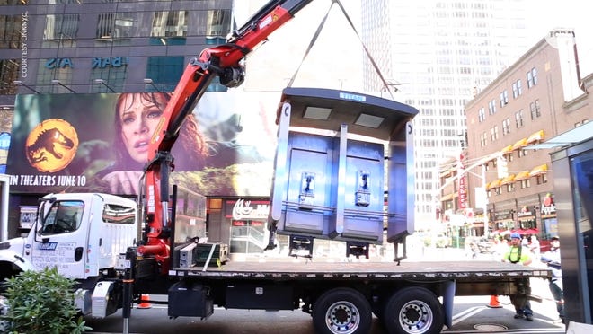 Workers in New York City remove the city's last public payphone near Seventh Avenue and 50th Street in Midtown Manhattan on May 23, 2022.