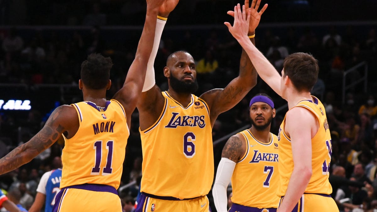 Lakers forward LeBron James (6) celebrates with guard Malik Monk (11) and guard Austin Reaves (15) during a game against the Wizards.