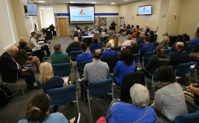 Teachers and staff fill the seats with an overflow crowd in the hall outside of the boardroom at the Akron Public School Board meeting to hear how the district is spending its stimulus dollars on Monday in Akron.
