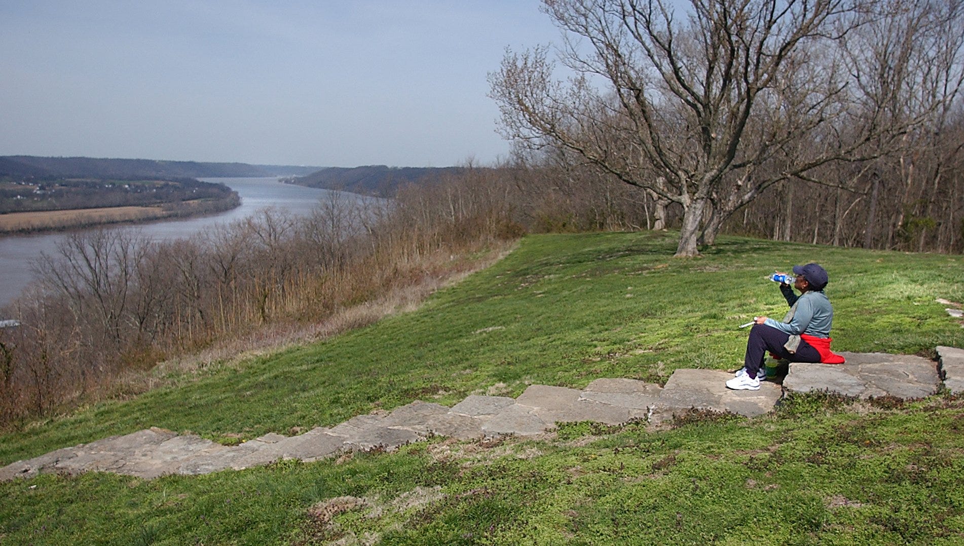 Joan Southgate, 73, of Cleveland, Ohio takes a drink of water during a moment of reflection in front of the John Rankin House overlooking the Ohio River in Ripley, Ohio near the start of her