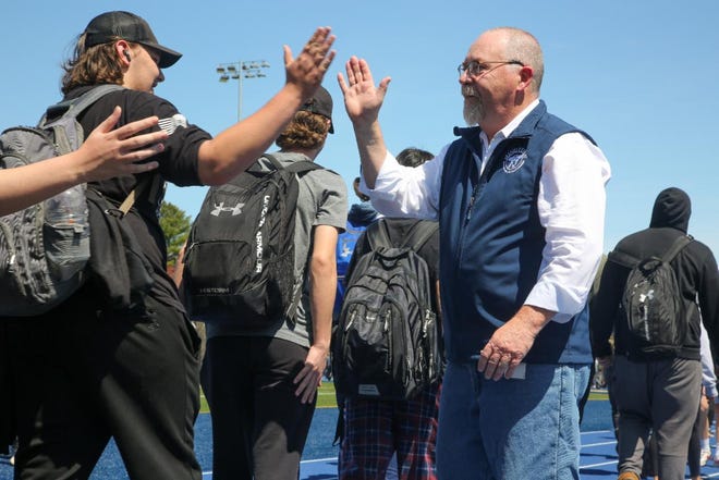Minuteman Superintendent-Director Edward A. Bouquillon, who will retire in June after leading the district for 15 years, gets some well-deserved high-fives during a parade of students and staff on Minuteman High School's new athletic track on May 12.