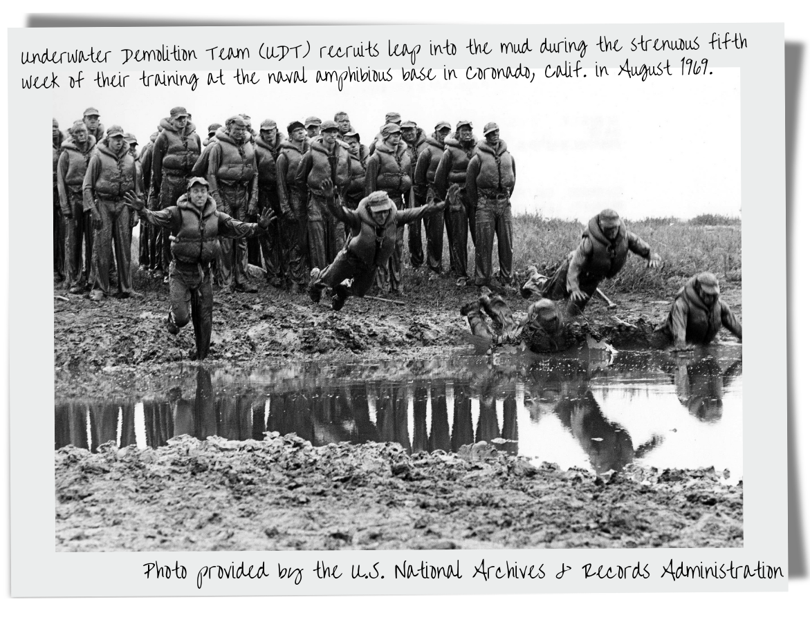 Underwater Demolition Team (UDT) recruits leap into the mud during the strenuous fifth week of their training at the naval amphibious base in Coronado, Calif. in August 1969.