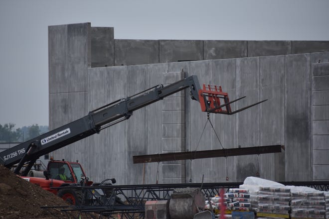 A worker at Timnath's 240-acre Ladera residential, commercial and mixed-use project, lifts a steel beam into place on a building Tuesday, May 24. The town is considering a Topgolf facility at the site located southeast of the intersection of Harmony Road and Interstate 25 south of Costco.