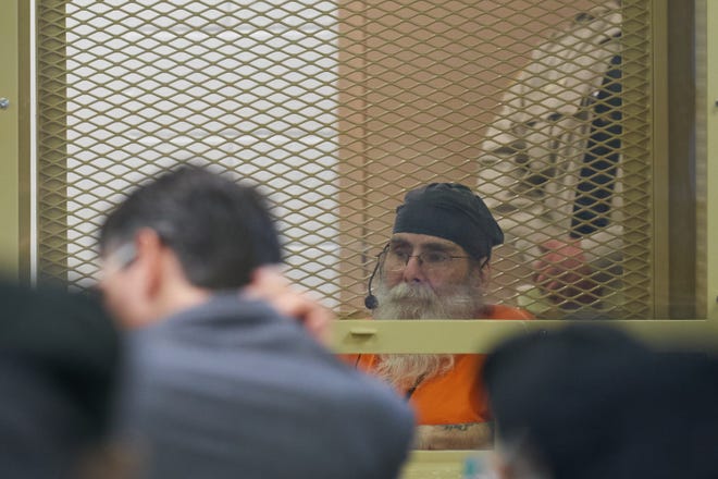 Frank Atwood, sitting inside a holding cell, listens to his clemency hearing at the Arizona State Prison Complex Eyman-Rynning Unit in Florence on May 24, 2022.