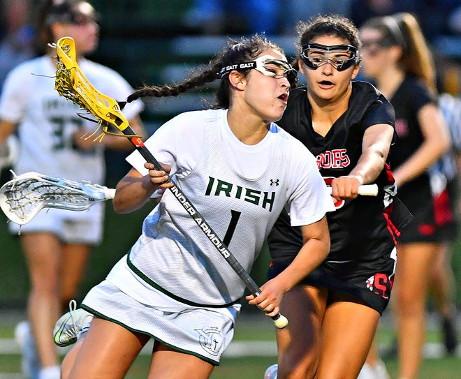 York Catholic's Olivia Staples, front, carries the ball down the field while Susquehannock's Sienna Kopp defends during PIAA District 3, Class 2-A girls' lacrosse semifinal action at York Catholic High School in York City, Monday, May 23, 2022. York Catholic would win the game 8-5. Dawn J. Sagert photo