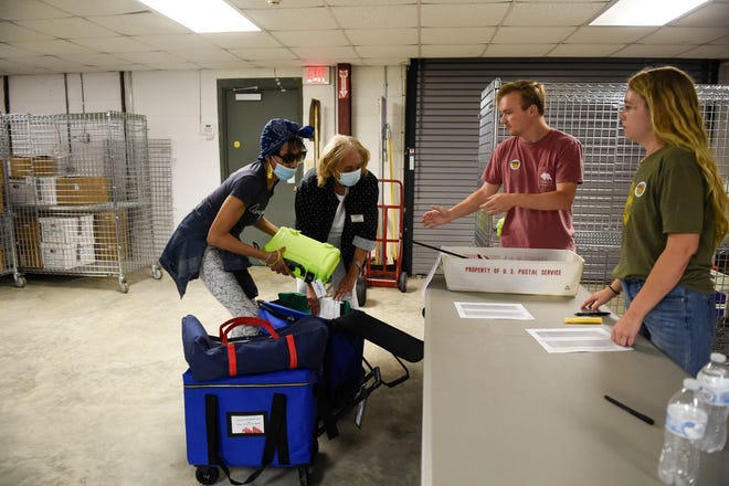 Constance Hampton (left) and Vivian Ransom (right) bring in electronic ballots after polls have closed to the Richmond County Board of Elections Warehouse on Tuesday, May 24, 2022, in Augusta, Ga. Polling officials started arriving around 8 p.m., about an hour after polls closed.