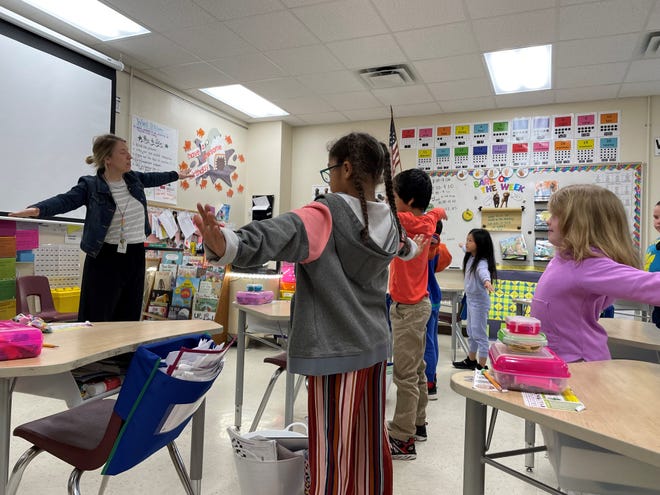 Fourth-graders fan their arms in a big stretch as part of mindfulness Wednesday at Tank Elementary School in Green Bay.