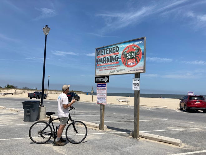 A man looks at a parking sign at Savannah Beach in Lewes on Monday, May 23, 2022.