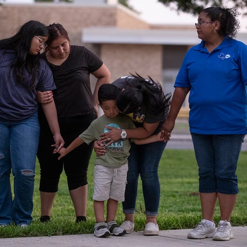 Community members gather in prayer at a downtown p