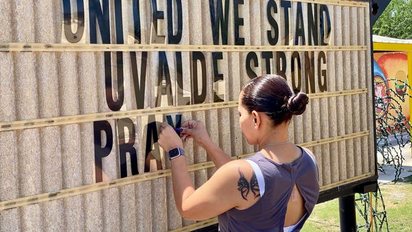 MaryAnn Garza, 37, completes a sign showing commun