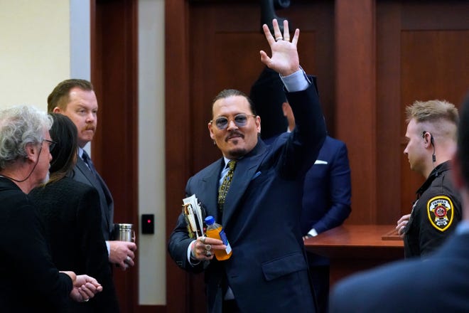 Actor Johnny Depp waves to the gallery as he leaves for a break in the courtroom in Fairfax, Va., on May 23, 2022.