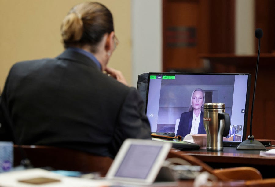 Actor Johnny Depp listens as his former girlfriend, Model Kate Moss, testifies via video link at the Fairfax County Circuit Courthouse in Fairfax, Virginia, on May 25, 2022.