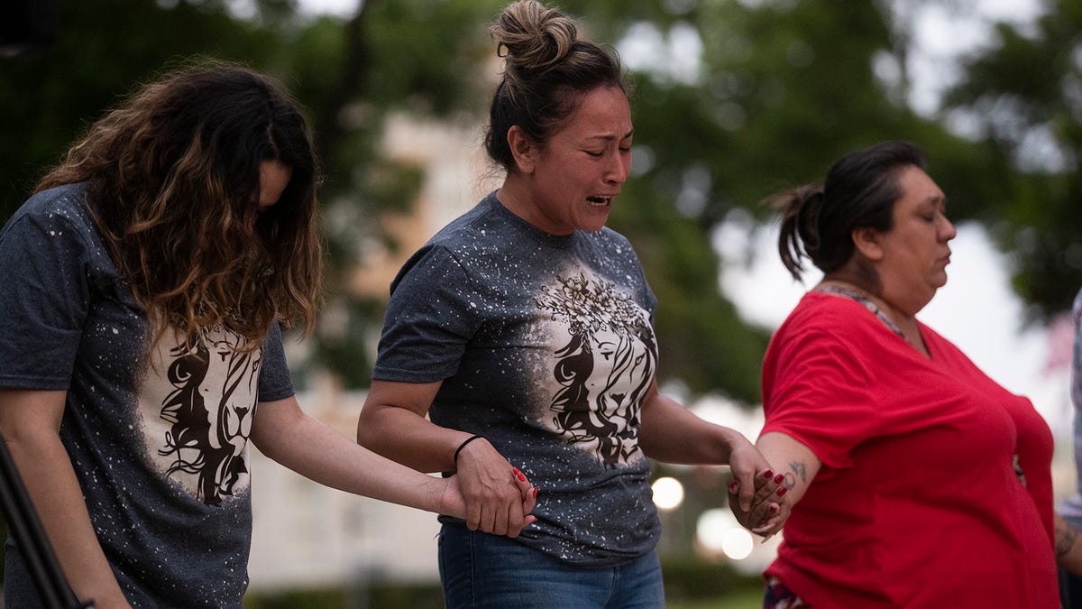 Gladys Castillon, middle, joins community members in prayer at the Uvalde downtown plaza following the shooting at Robb Elementary School in Uvalde, Texas on Tuesday, May 24, 2022. The shooting killed 19 children and two adults. 