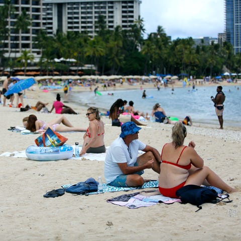 Brett Walsh and Emma Yates sit in the sun on Waiki