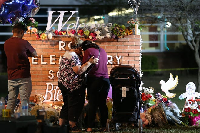 Albert Martinez, from left, Elida Gonzales, Amber Gonzales and Nyla Martinez, in her stroller, visit the memorial at Robb Elementary School Wednesday, May 25, 2022, in Uvalde. At least 19 students and two adults died in a shooting at a Robb elementary school Tuesday, marking the deadliest school shooting in the state's history.