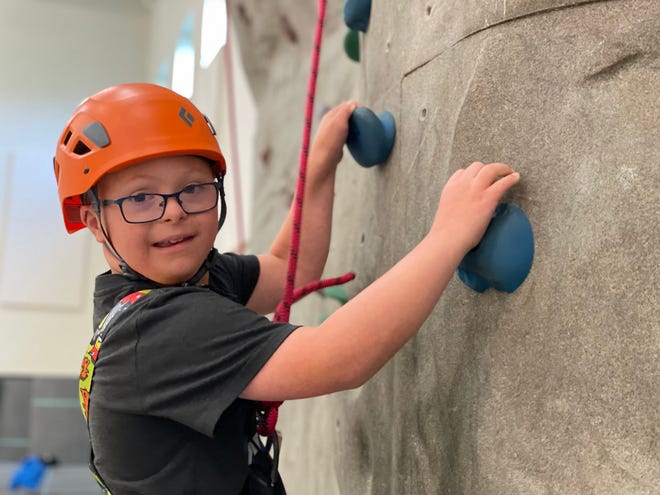 A camper on the indoor climbing wall at Recreation Unlimited