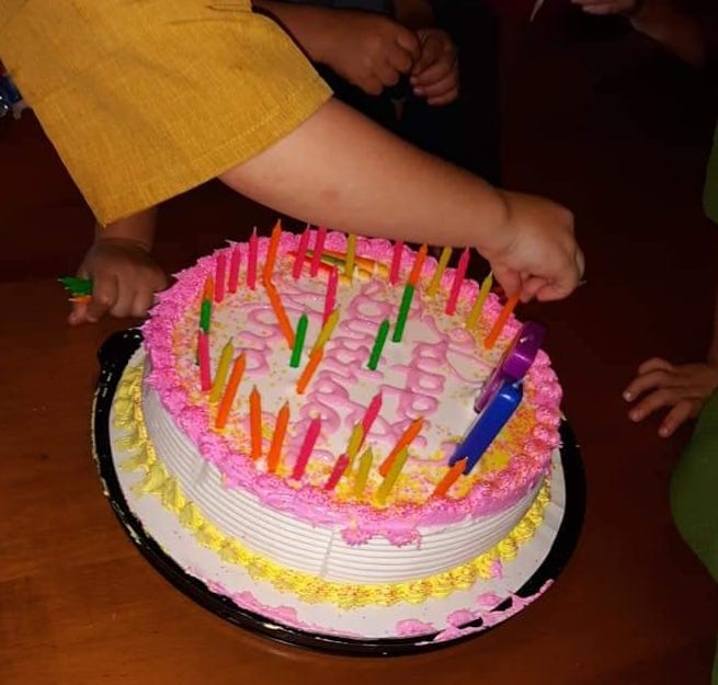 The grandchildren work on adding 51 candles to Lovina’s birthday cake.
