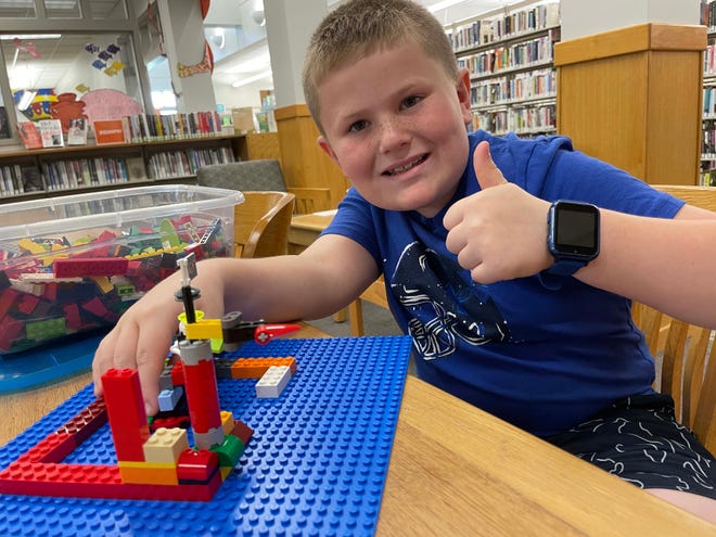 Easton Baumgardner, 9, builds a naval base complete with defensive turrets at the monthly LEGO Club at Karns Branch Library Saturday, May 21, 2022.