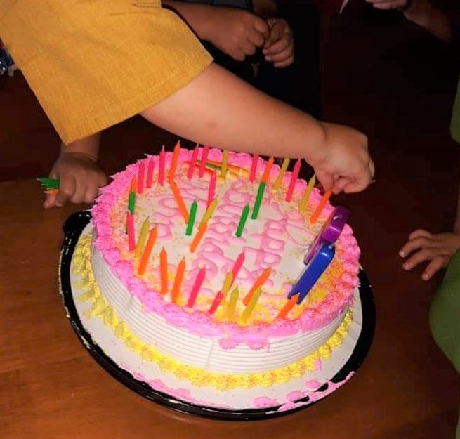 The grandchildren work on adding 51 candles to Lovina’s birthday cake.