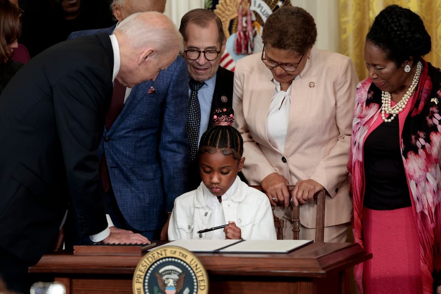 Gianna Floyd, the daughter of George Floyd, holds a pen used by U.S. President Joe Biden to sign an executive order enacting further police reform in the East Room of the White House on May 25, 2022 in Washington, DC.