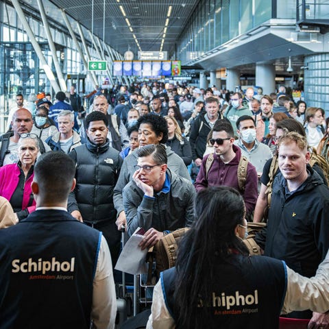 Travelers wait in a departure hall at Schiphol air