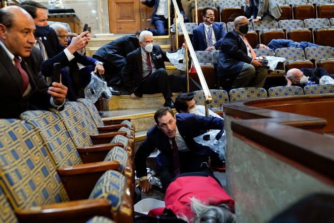 Members of Congress shelter in the House gallery as protesters storm the U.S. Capitol on Jan. 6, 2021.