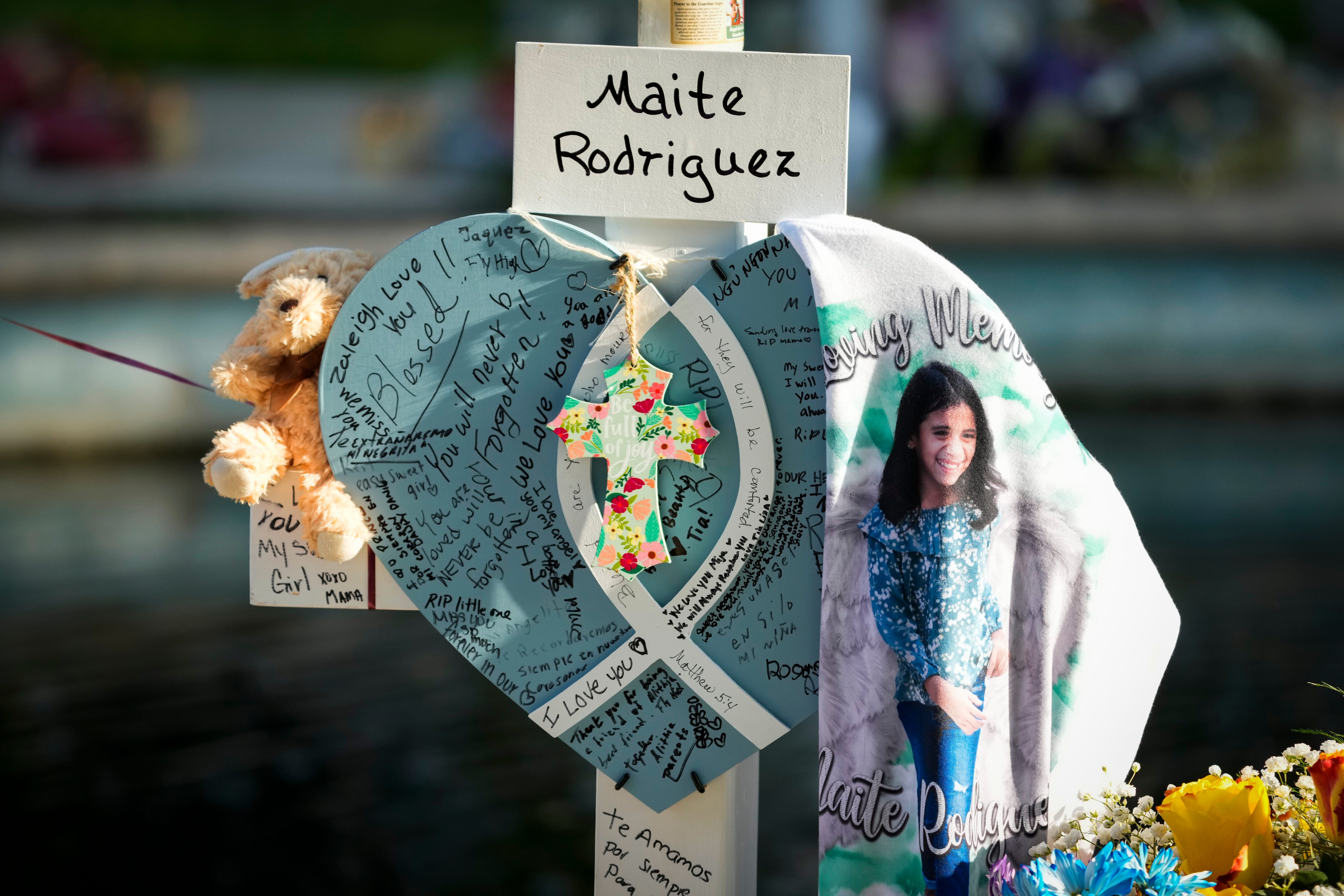 A memorial cross for Maite Rodriguez, one of the 19 children killed at Robb Elementary School, is decorated with mementos and personal notes in Uvalde's town square.