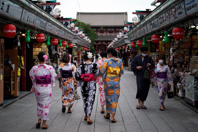 FILE - Tourists in traditional Japanese kimonos walk in Asakusa district in Tokyo, July 27, 2020. Japan will reopen its borders to foreign tourists June 10, 2022, but only to package tour participants for now, officials said Thursday, as the country starts to cautiously open its borders to foreign tourism for the first time in about two years. (AP Photo/Eugene Hoshiko, File)