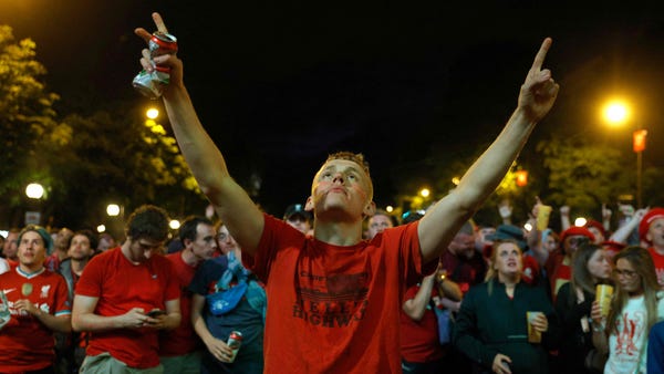A Liverpool FC's supporter gestures near Place de 