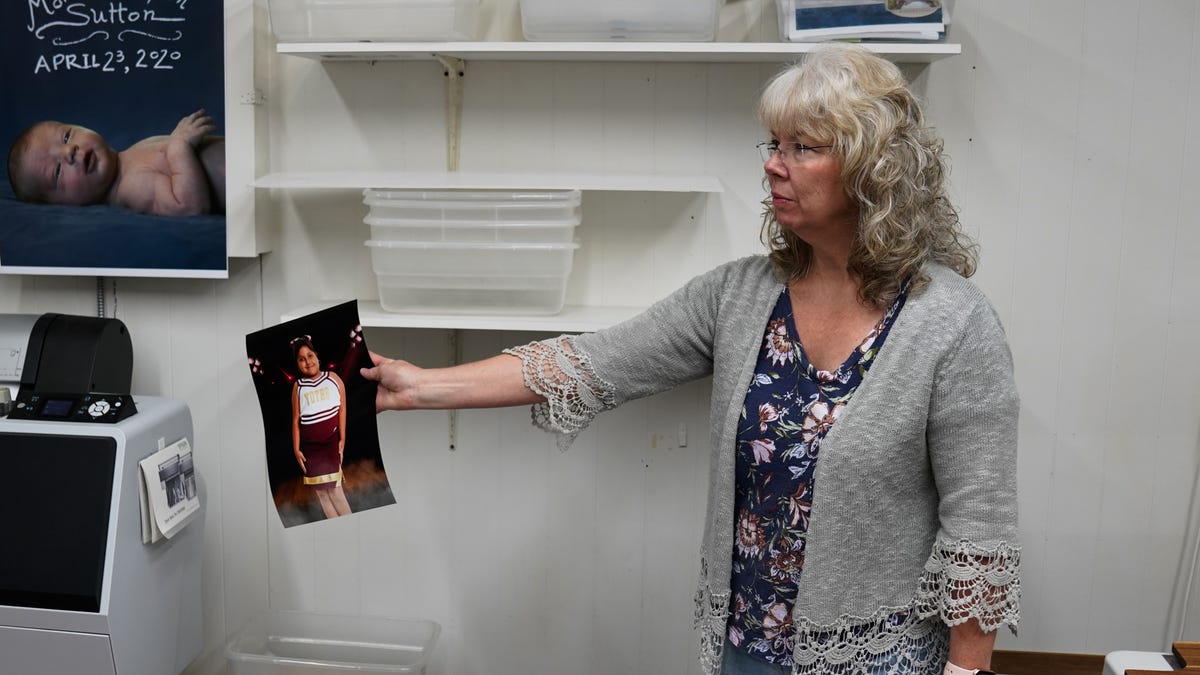 Nancy Sutton inspects a print of a school portrait of Ellie Garcia, who was killed in the May 24, 2022, mass shooting in Uvalde, Texas. Nancy and Art Sutton, who own Uvalde Photo and take student pictures every year, have been making free prints for the families of the 19 dead students and two murdered teachers.