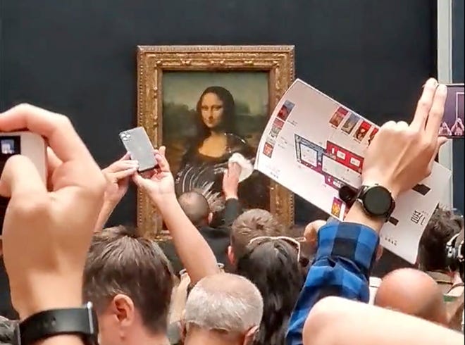 Mona Lisa ditabrak kue yang dilemparkan oleh pria yang memakai wig